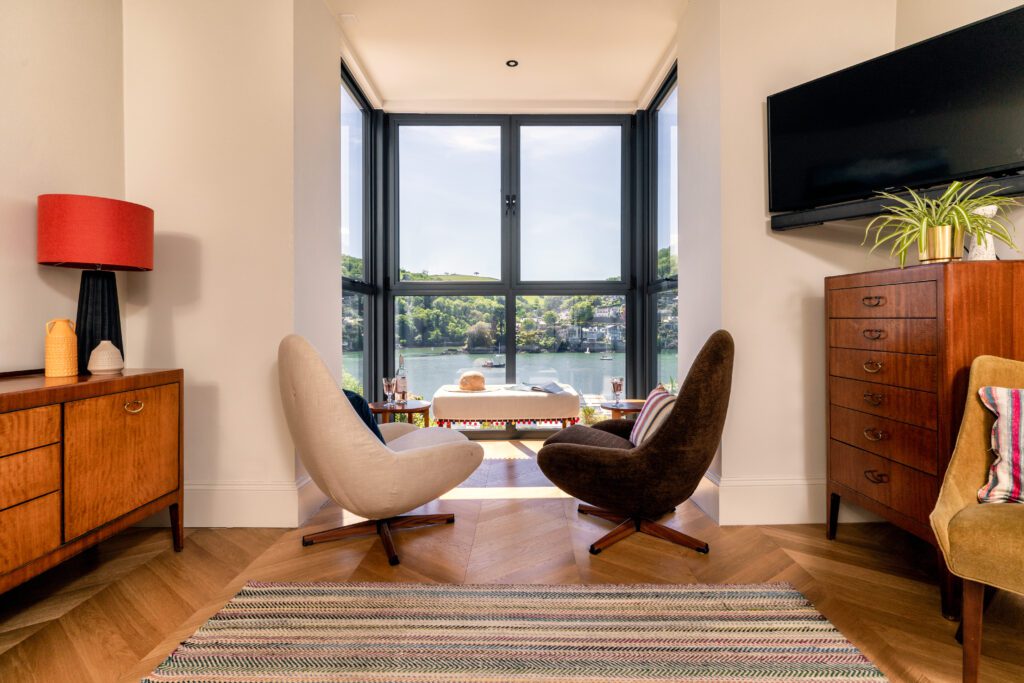 A glass-fronted gem in Kingswear, blending mid-century charm with stunning river and sea views. Architectural Interior Photography by Sue Vaughton