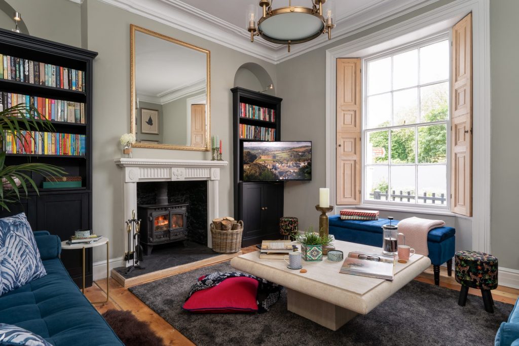 St Maur Cottage Totnes – Georgian living room with heritage details, wood burning stove, and acres of books. Photography by Sue Vaughton.