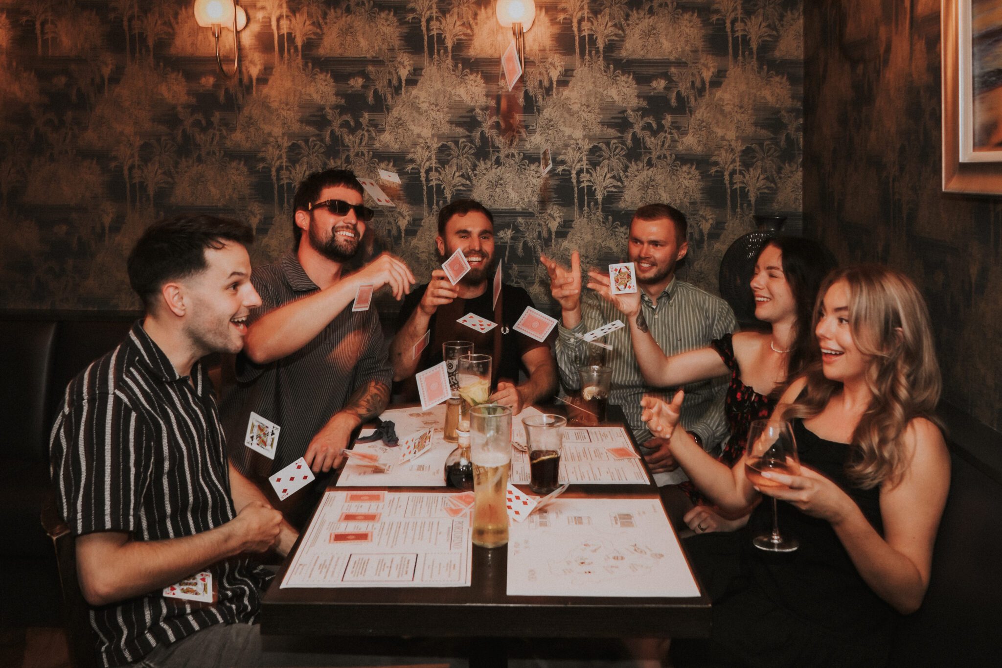 Friends enjoying drinks and playing cards together at Portofino Italian Bar & Restaurant in Wellswood, Torquay